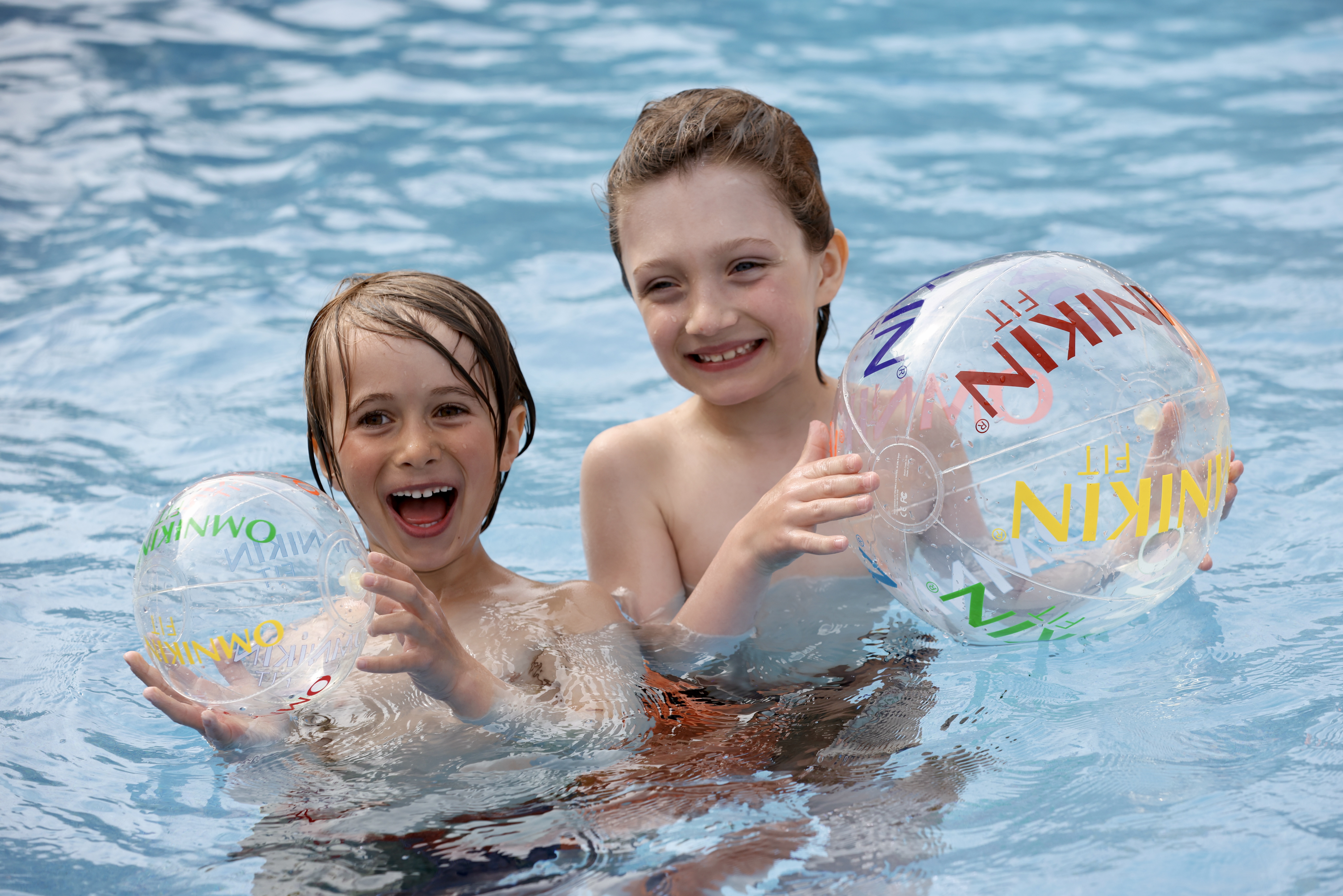 omnikin fit balls (6 and 12 inches) with 2 kids in pool